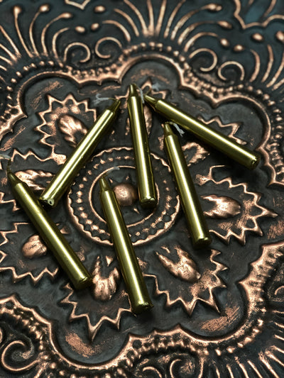 Six gold chime candles laid out on a table.