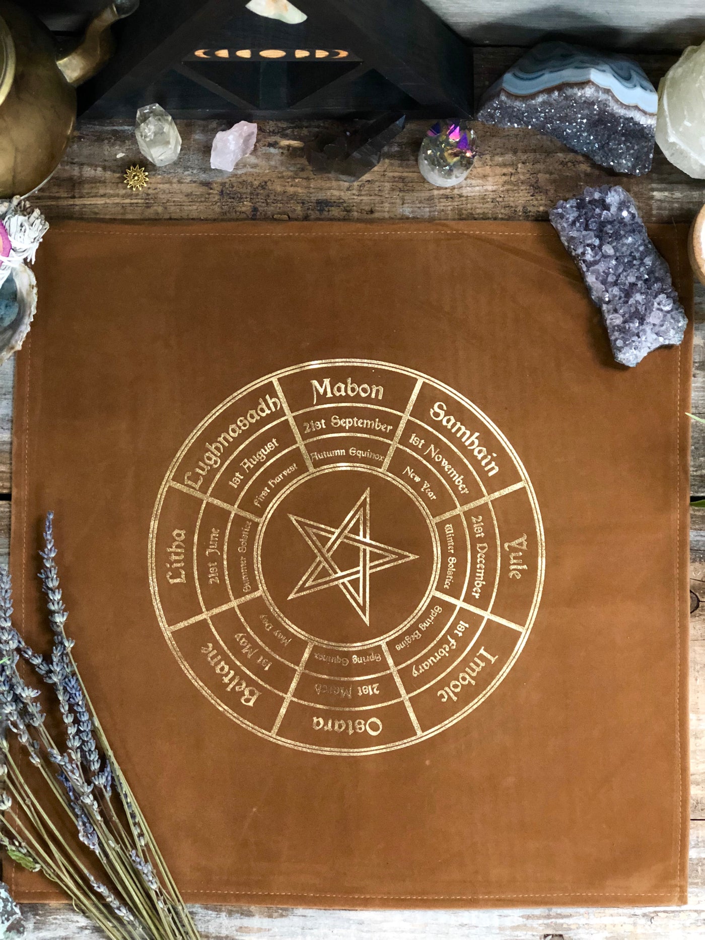 Close up of the Wheel of the Year Altar Cloth. Brown with gold lettering. 