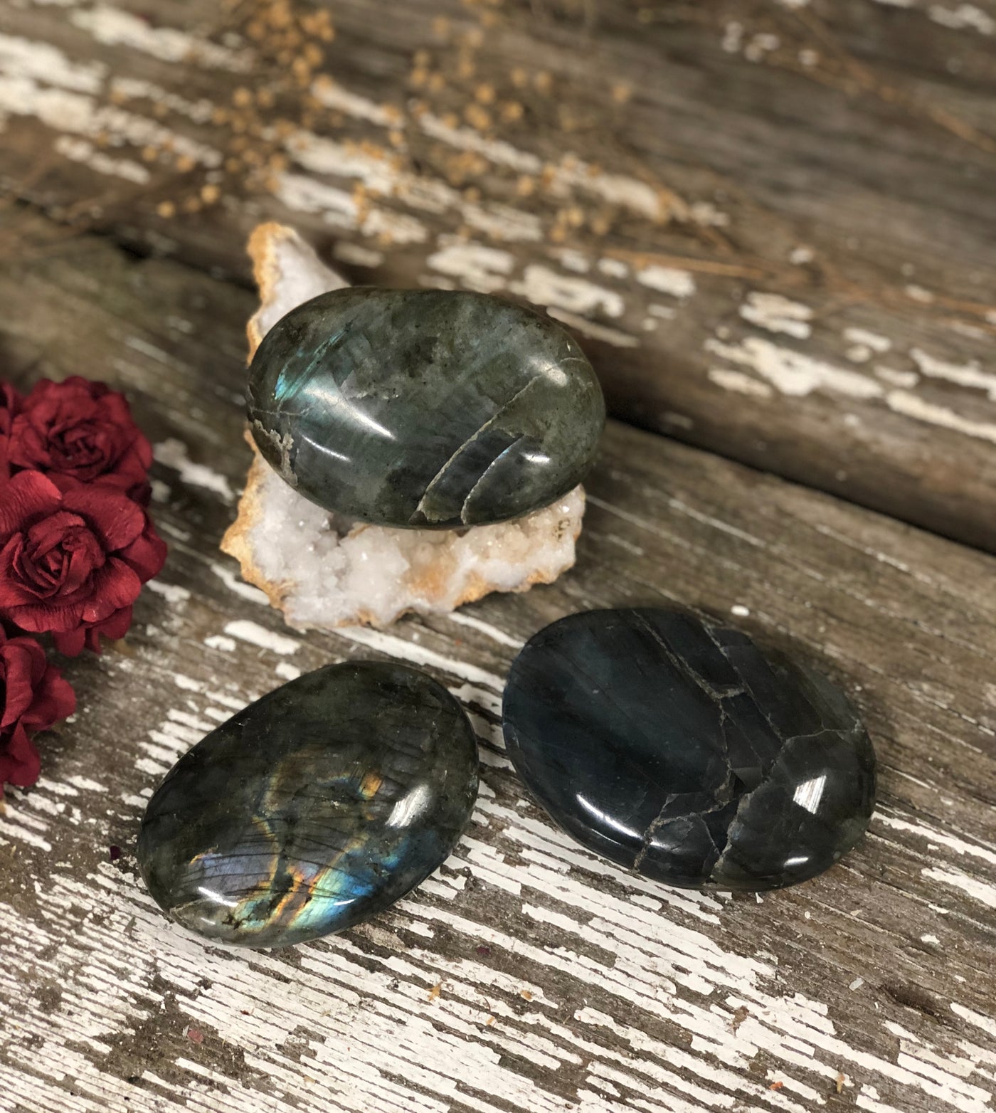 Three palm stones displayed on a wooden board.