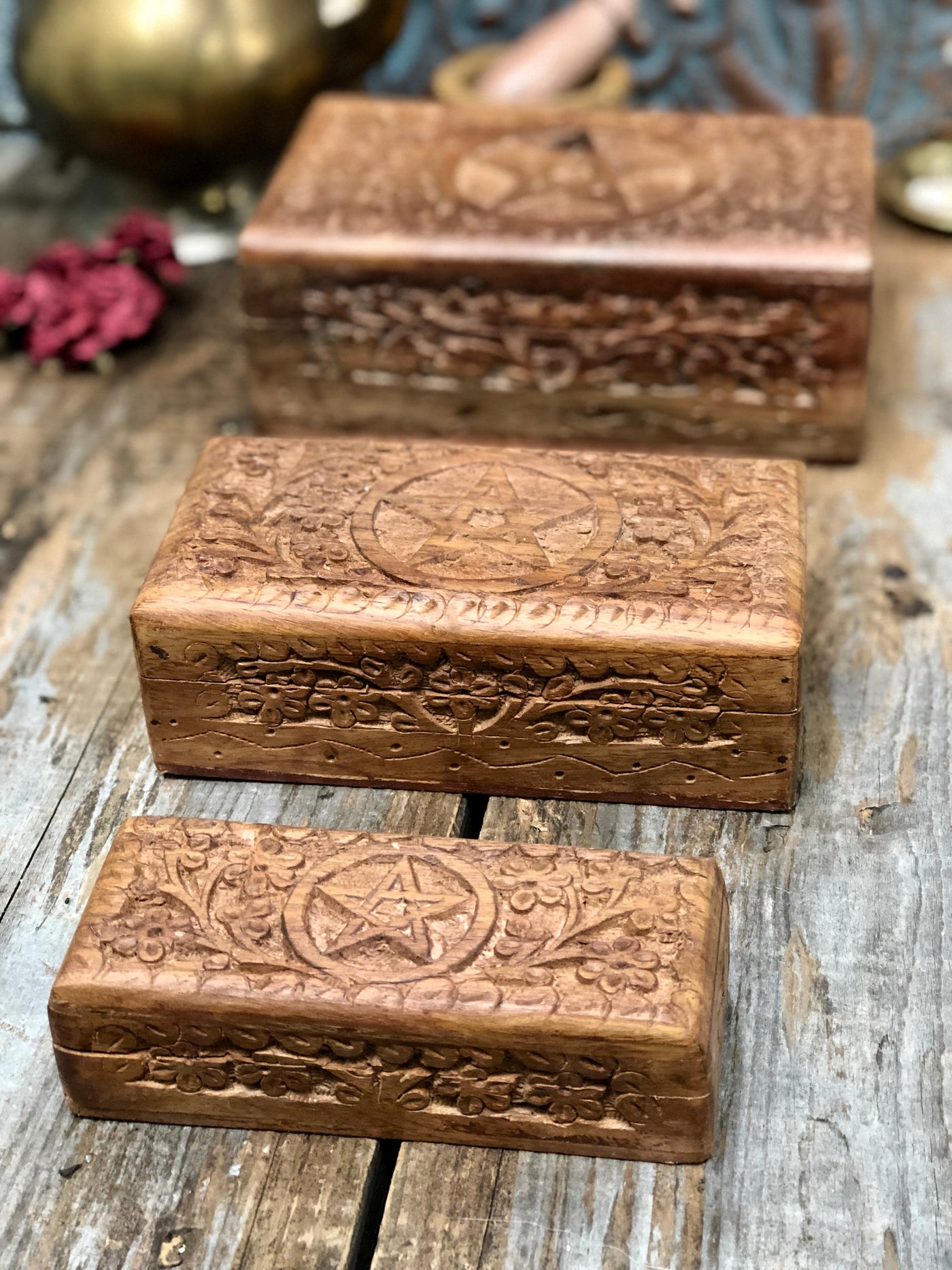 Three wooden boxes carved with a pentagram on the lid.
