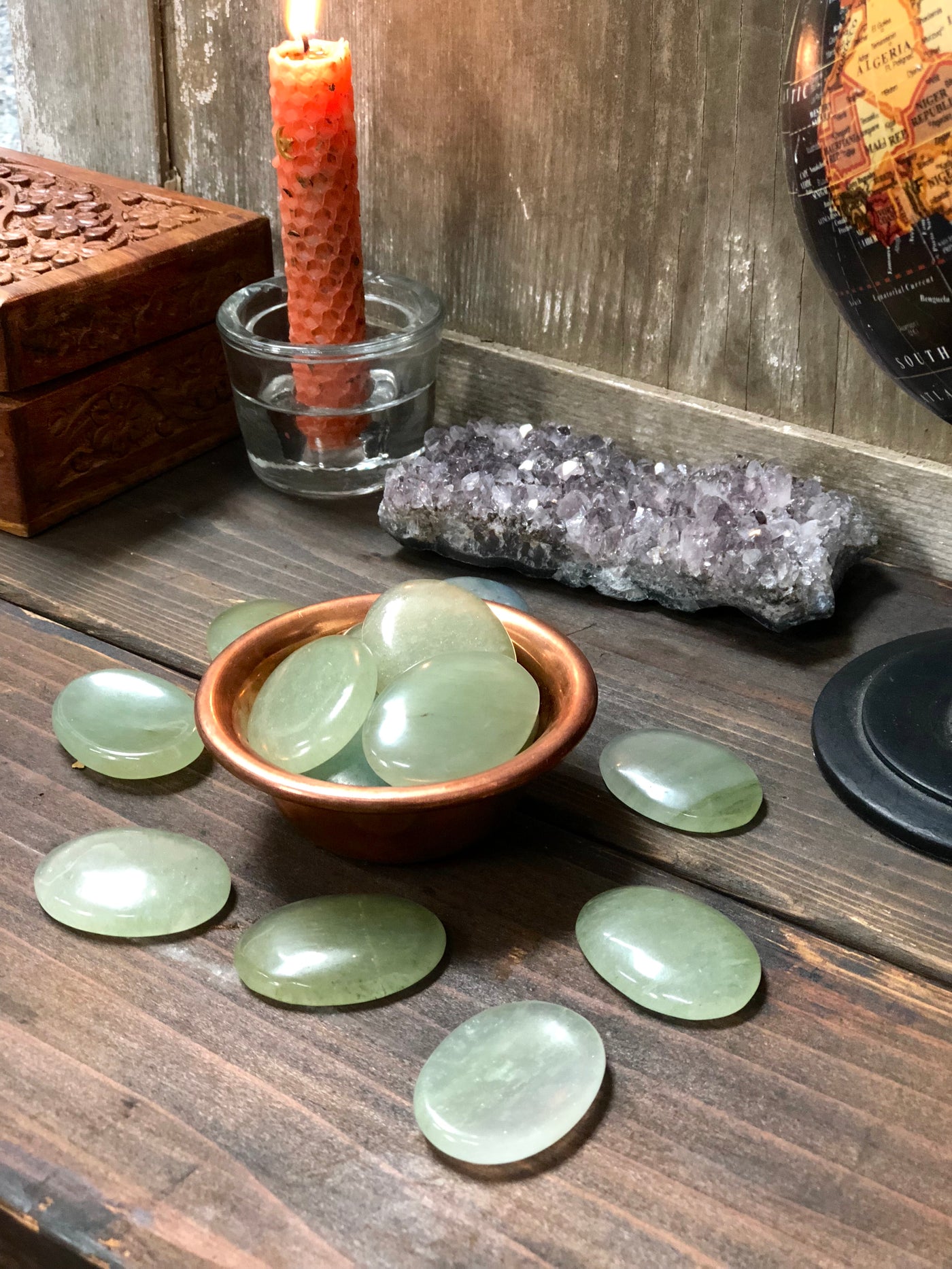 Green worry stone in a bowl and displayed on a table. 